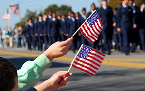 Airmen Marching in Parade Past Flags