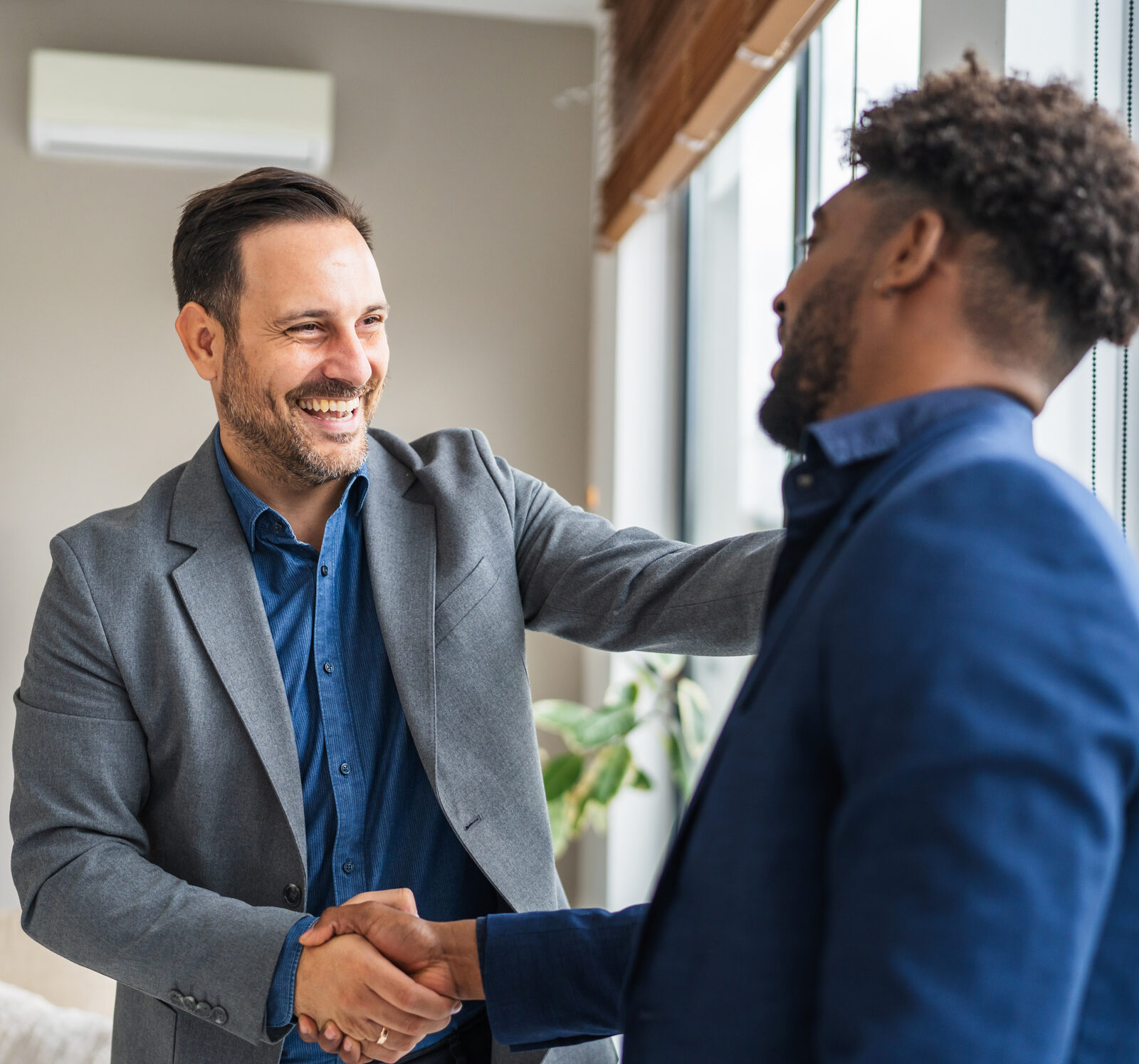 Two professionals shaking hands and smiling