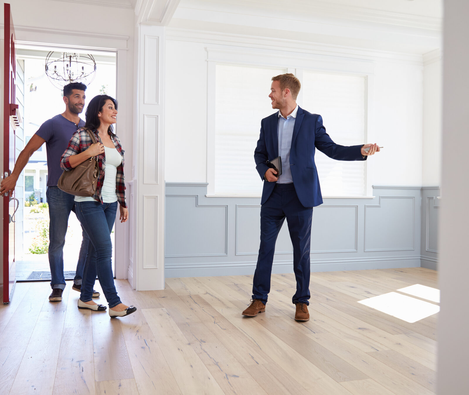 Real estate agent showing a bright, empty home to a couple