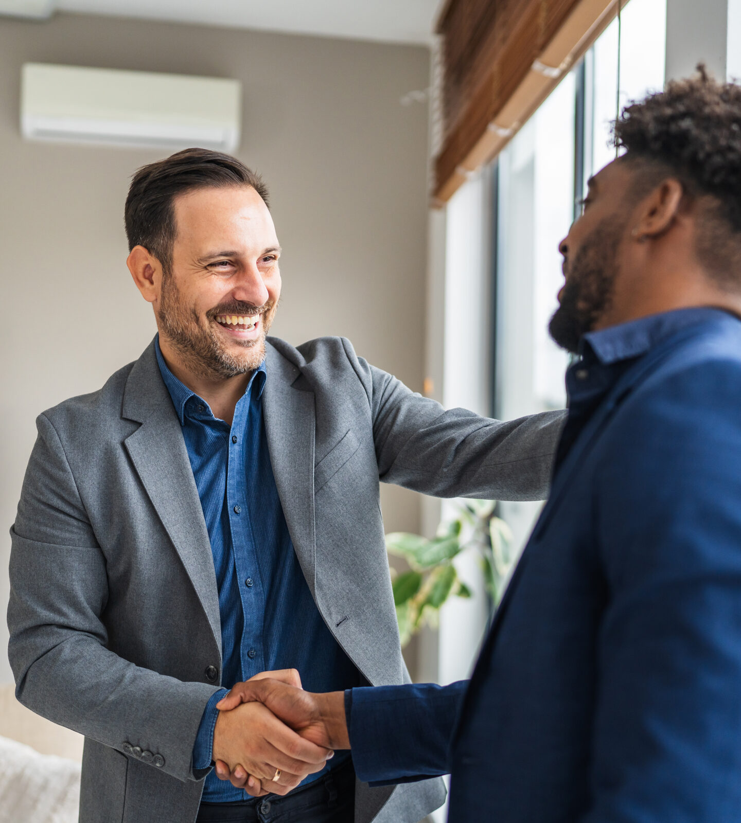 Two professionals shaking hands and smiling